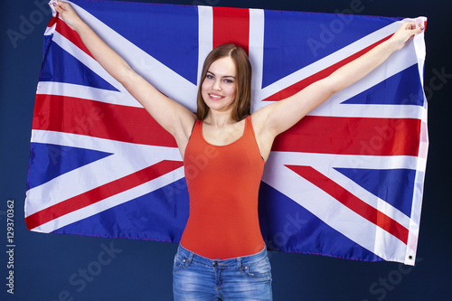 Happy young woman holding a flag of of Great Britain (British fl