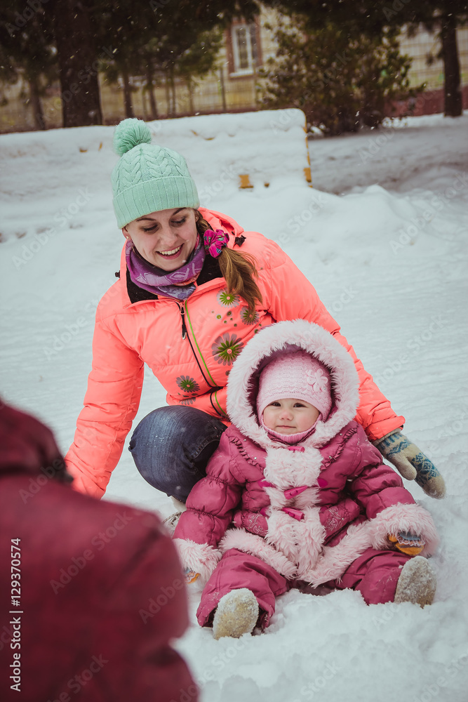 happy family mother and baby girl daughter in winter outdoors