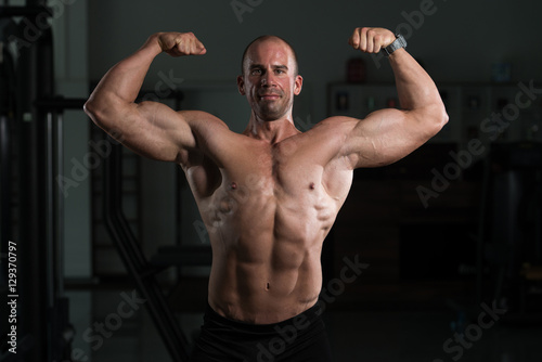 Bodybuilder Fitness Model Posing Double Biceps After Exercises