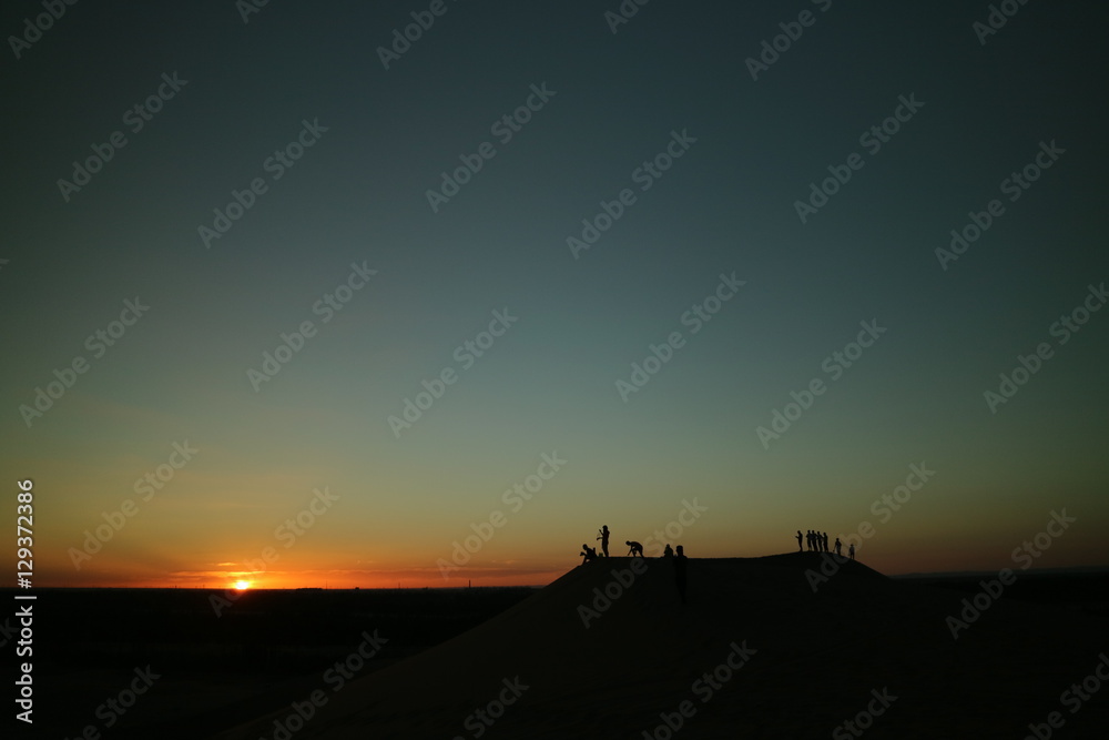 jovens assistindo o pôr do sol do alto de um monte. jovens assistindo o pôr do sol do alto de um monte.