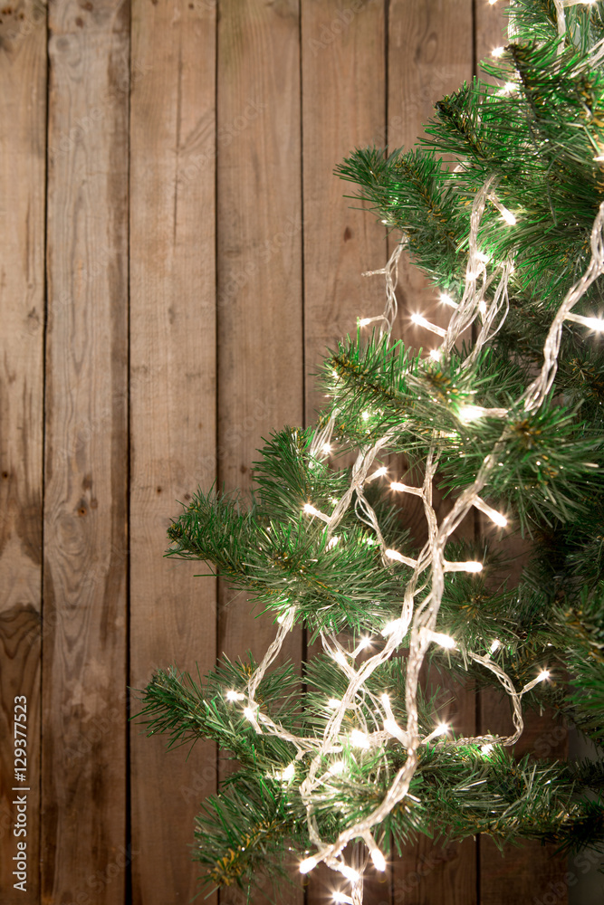 Christmas tree with lights on the wooden background Christmas tree with lights on the wooden background