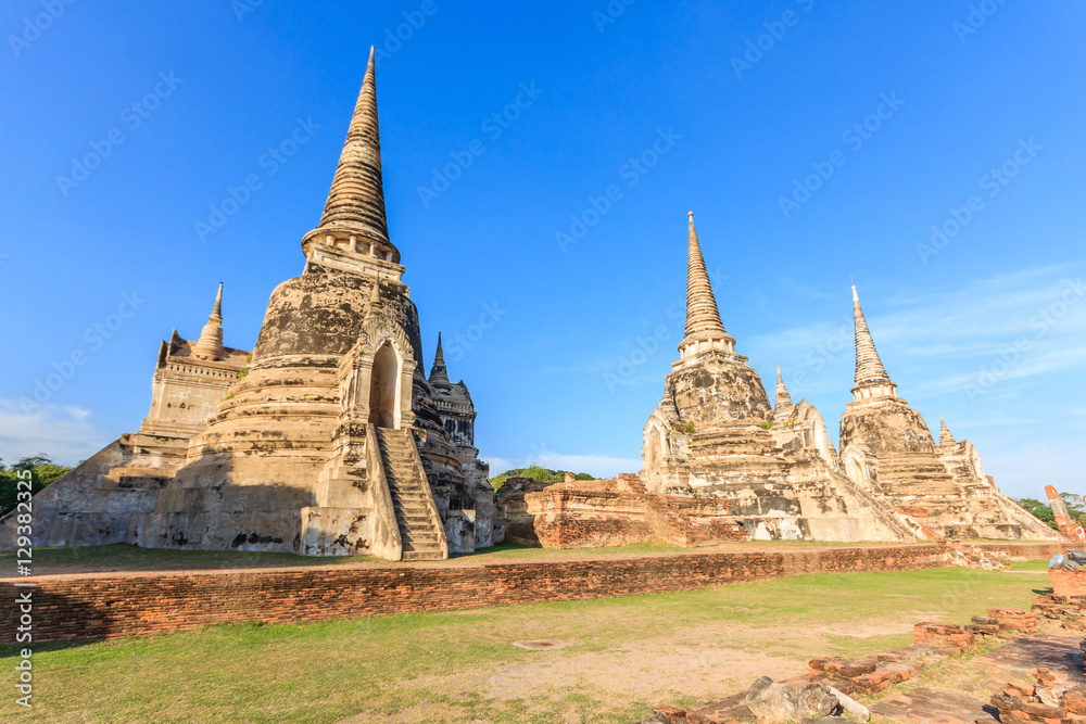 Young woman praying to giant reclining buddha statue at Wat Lokayasutharam, Ayutthaya Historical Park, Ayutthaya, Thailand.