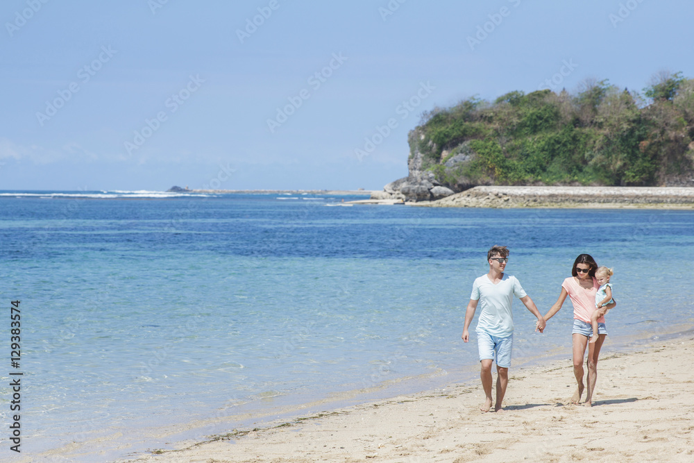 young mother holding hands with her husband while carrying her l young mother holding hands with her husband while carrying her l