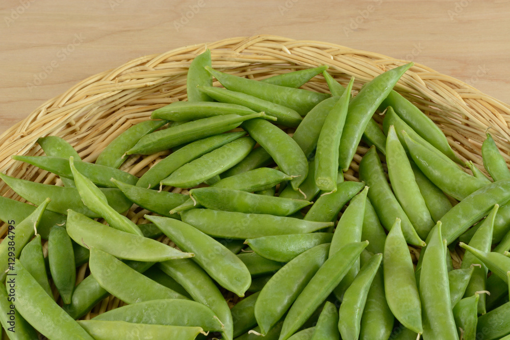Close up of Green snap beans in wood basket in preparation for removing strings