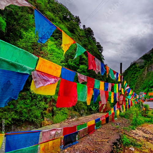 Buddhist prayer flags the holy traditional flag along site the way to Holy snow mountains in Yading nature reserve, China.