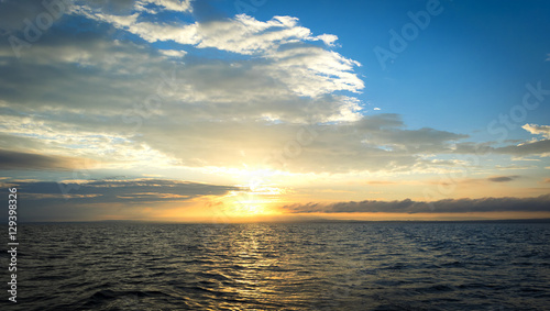 Sunset sky background. Dramatic gold sunset sky with evening sky clouds over the sea. Stunning sky clouds in the sunset. Sky landscape. 
