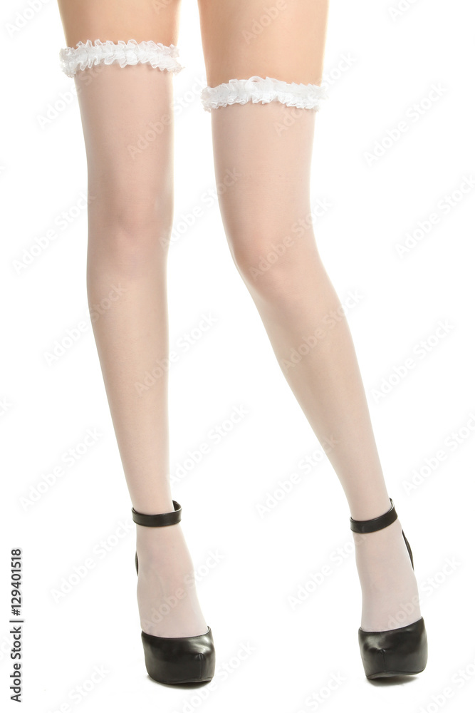 Beautiful female legs in sexy white stockings and black high heels. Isolated on white background. Beautiful female legs in sexy white stockings and black high heels. Isolated on white background.