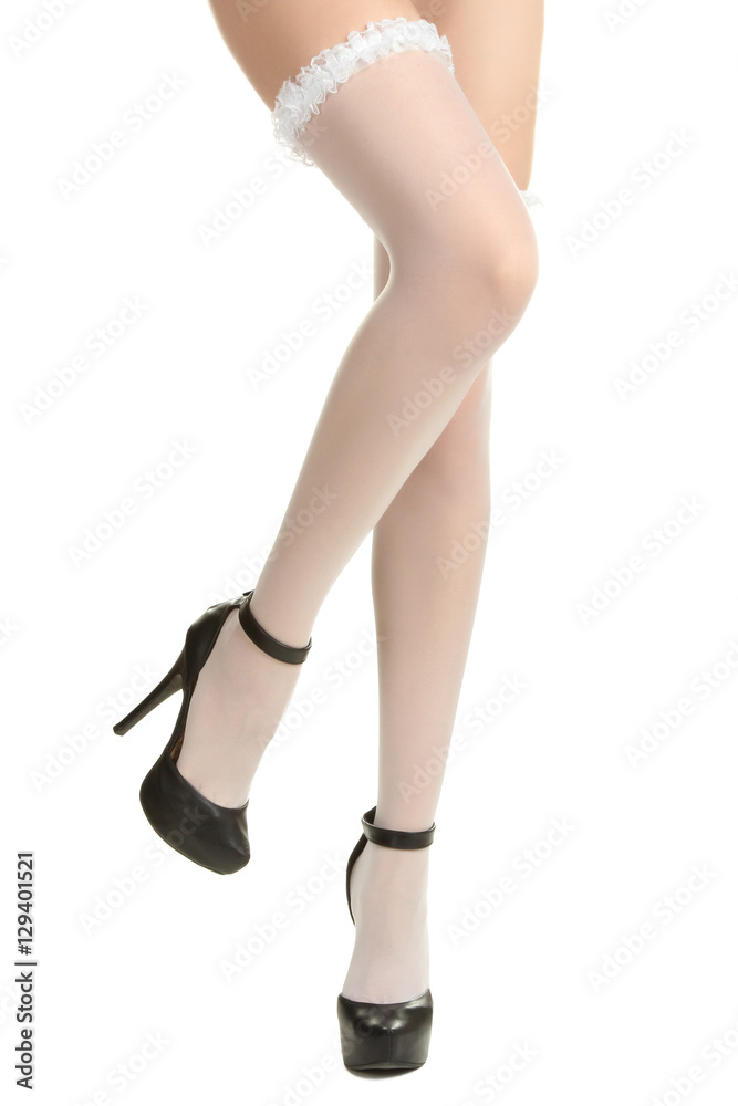 Beautiful female legs in sexy white stockings and black high heels. Isolated on white background. Beautiful female legs in sexy white stockings and black high heels. Isolated on white background.