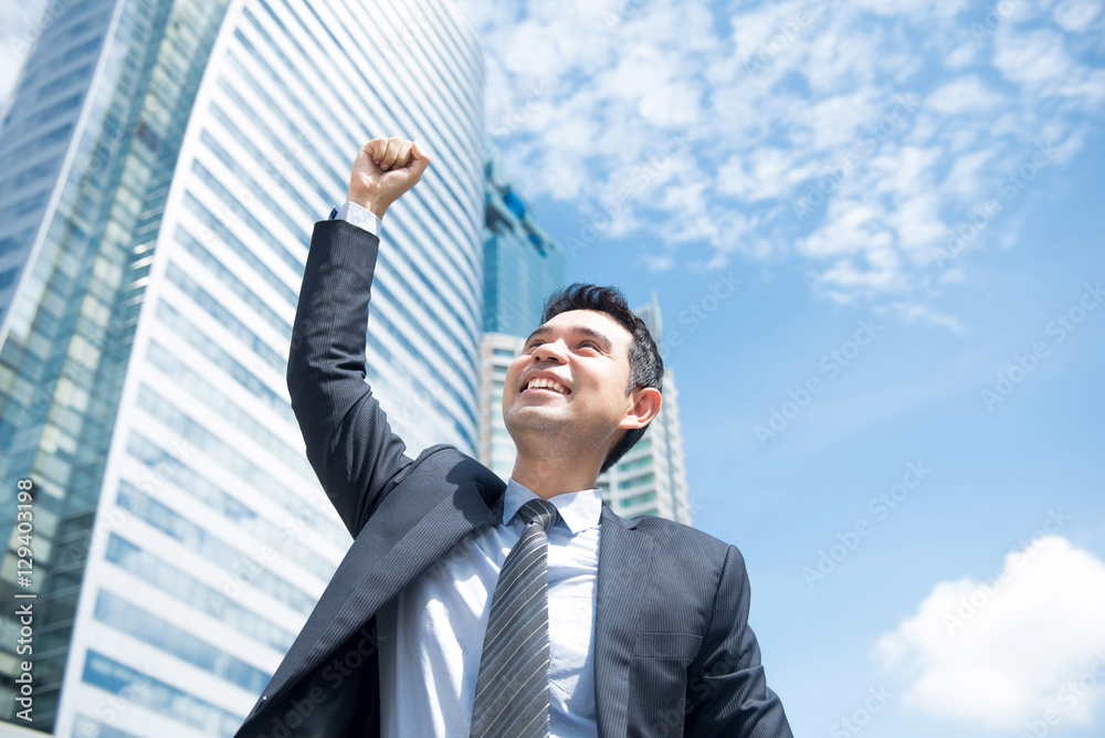 Businessman smiling and raising his fist in the air Businessman smiling and raising his fist in the air