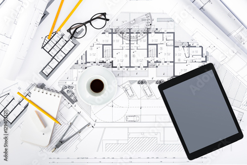 Construction plans with Tablet and drawing Tools on blueprints