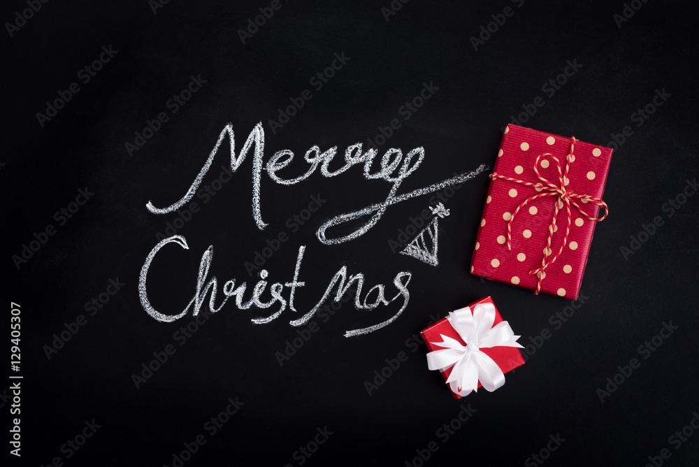 Merry Christmas text with red gift boxes on blackboard