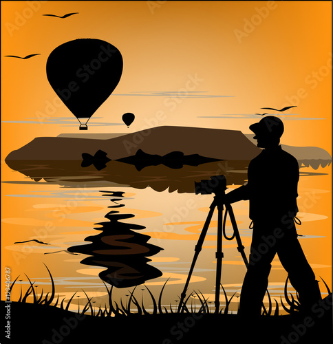 Photographer silhouette at sunset and flying balloons