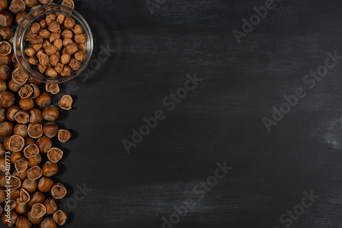 Hazelnuts in a bowl on the chalkboard. © Dmytro Holbai