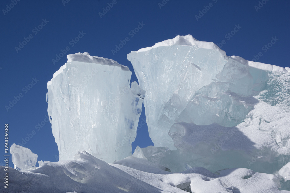 Huge blocks of aqua ice on blue sky background. Winter backdrop.