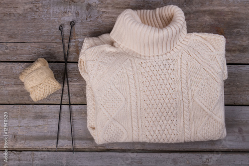 Quadro em tela White knitted sweater with yarn and knitting needles.