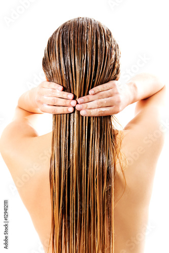 Woman applying hair conditioner. Isolated on white.