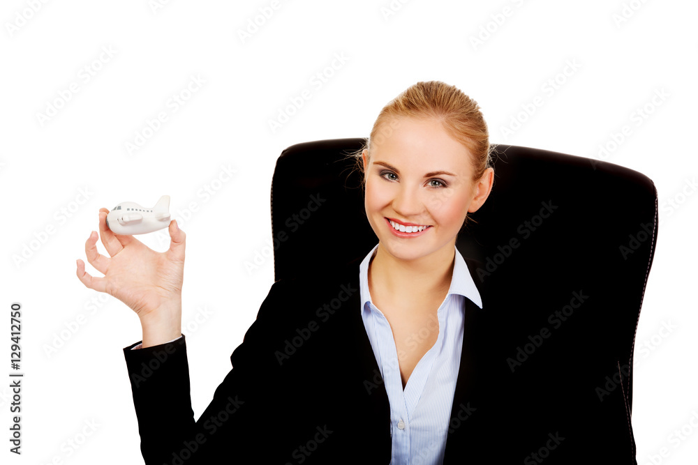 Business woman sitting on wheel chair and holding toy plane Business woman sitting on wheel chair and holding toy plane