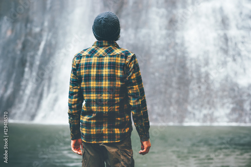 Man looking at waterfall Travel Lifestyle adventure concept vacations into the wild