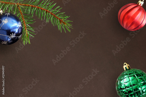 Dark background with Christmas fir branch, blue, green ribbed and red wavy ball photo