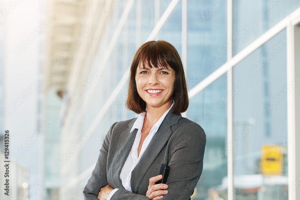 Business woman holding cellphone with arms crossed Business woman holding cellphone with arms crossed