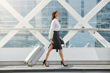 business woman walking with suitcase in terminal