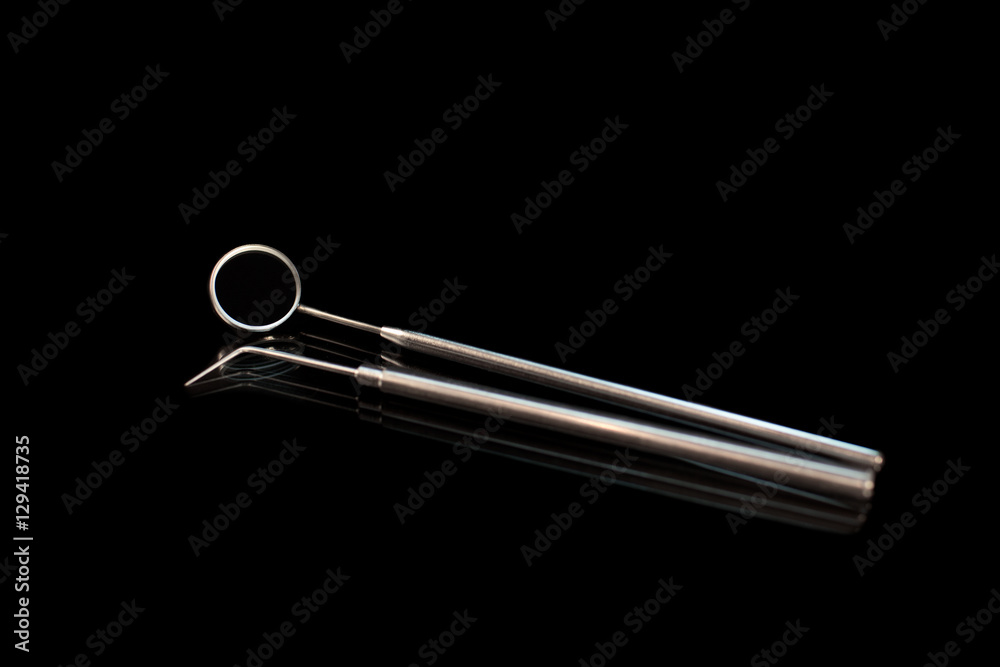 Dental mirror and dentist probe. Image isolated on black background Dental mirror and dentist probe. Image isolated on black background