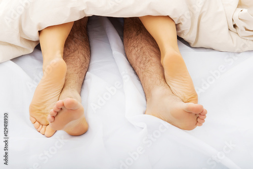Couple's feet in bed.