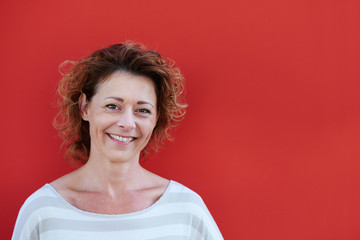 Smiling older woman against red background