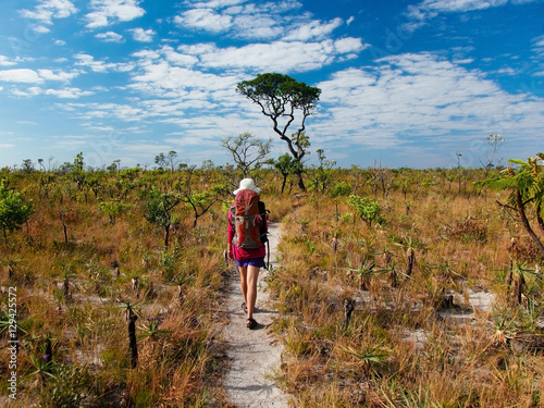 Young woman hiking in the savannah with a backpack