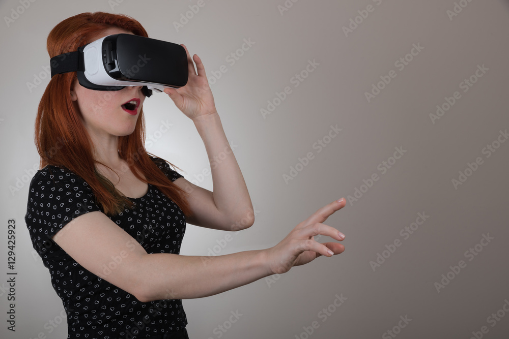Woman in VR headset looking up and trying to touch space Woman in VR headset looking up and trying to touch space