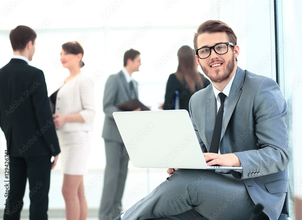Portrait of a handsome young business man with people in background at office meeting Portrait of a handsome young business man with people in background at office meeting