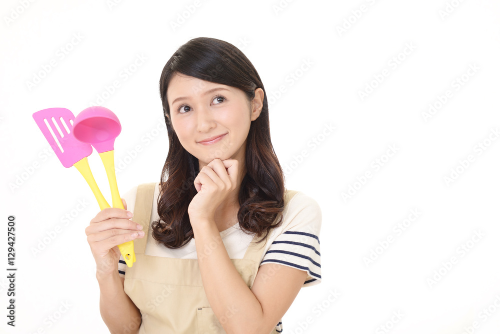 調理器具を持つ笑顔の主婦