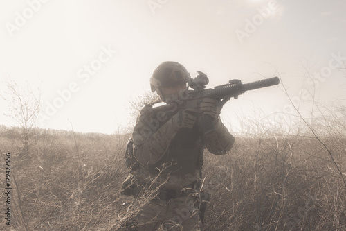 Airsoft soldiers in uniform on the battlefield running in fog