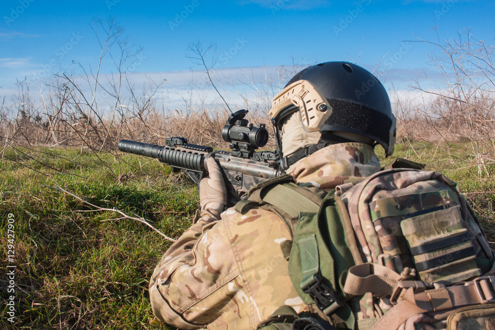 Fototapeta premium airsoft player in NATO uniform with rifle in ambush close up picture