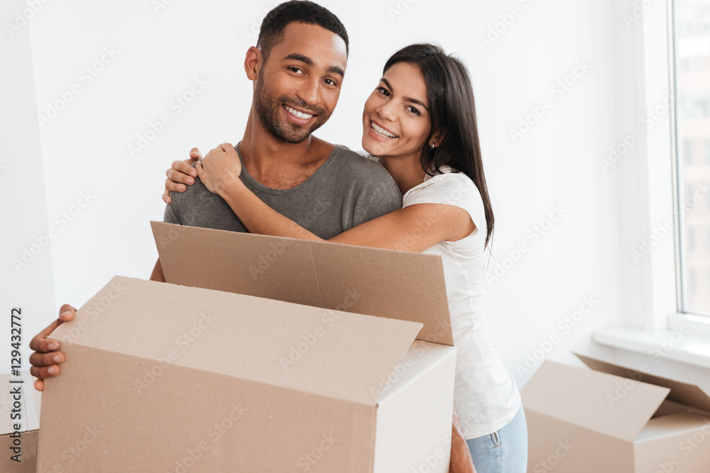 Happy couple standing with unpacked boxes Happy couple standing with unpacked boxes