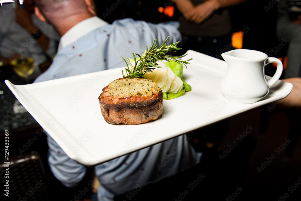 Man carries fried meat on square plate Man carries fried meat on square plate