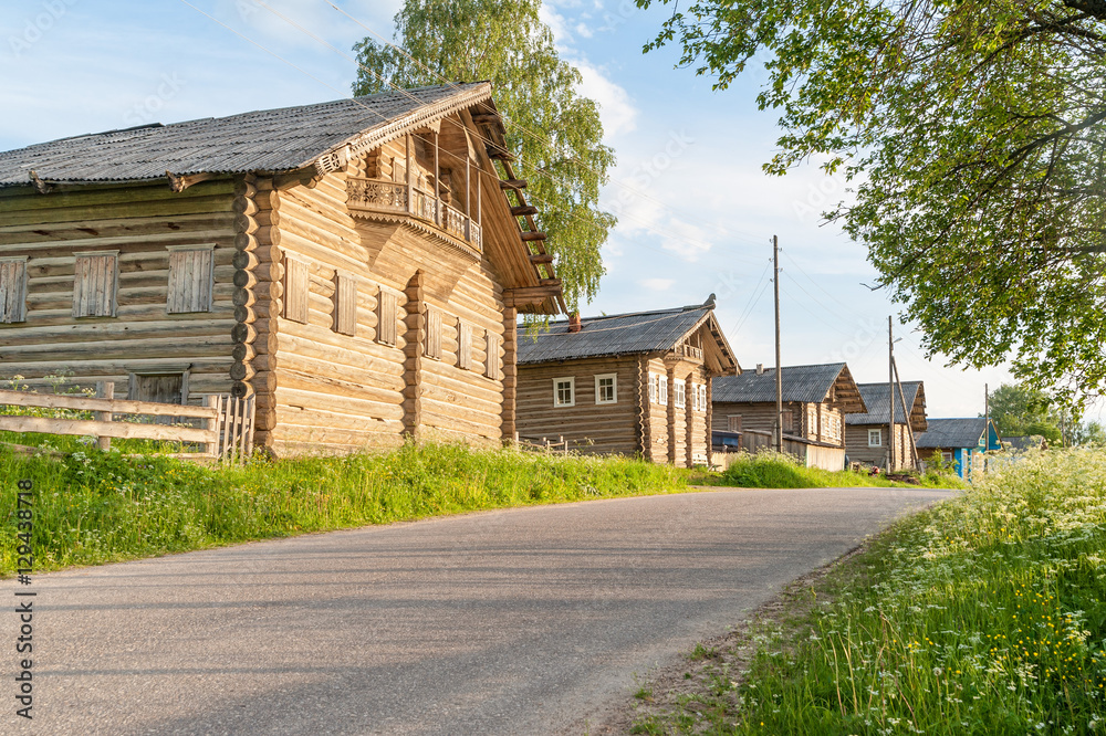 Old wooden house with fretted balcony and nailed up windows among others on village street against blue sky background. Arkhangelsky region, Russia.
Old wooden house with fretted balcony and nailed up windows among others on village street against blue sky background. Arkhangelsky region, Russia.