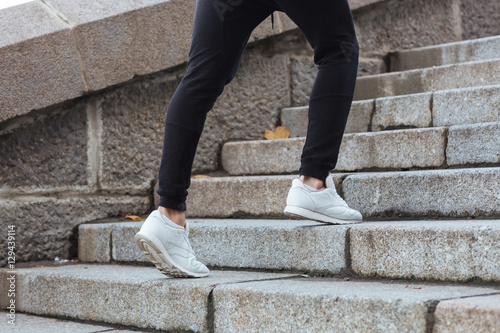 Man legs running on stairs outdoors