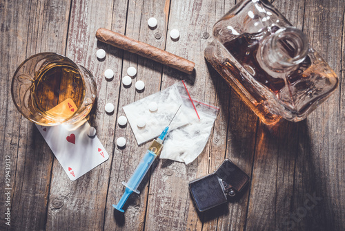 Hard drugs and alcohol on an old wooden table