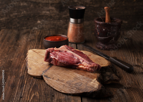 Raw Steak T-Bone with spices and mortar with pepper