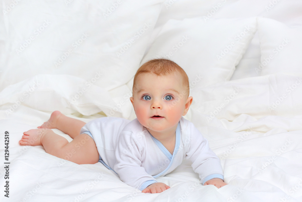 Baby in white bedding.