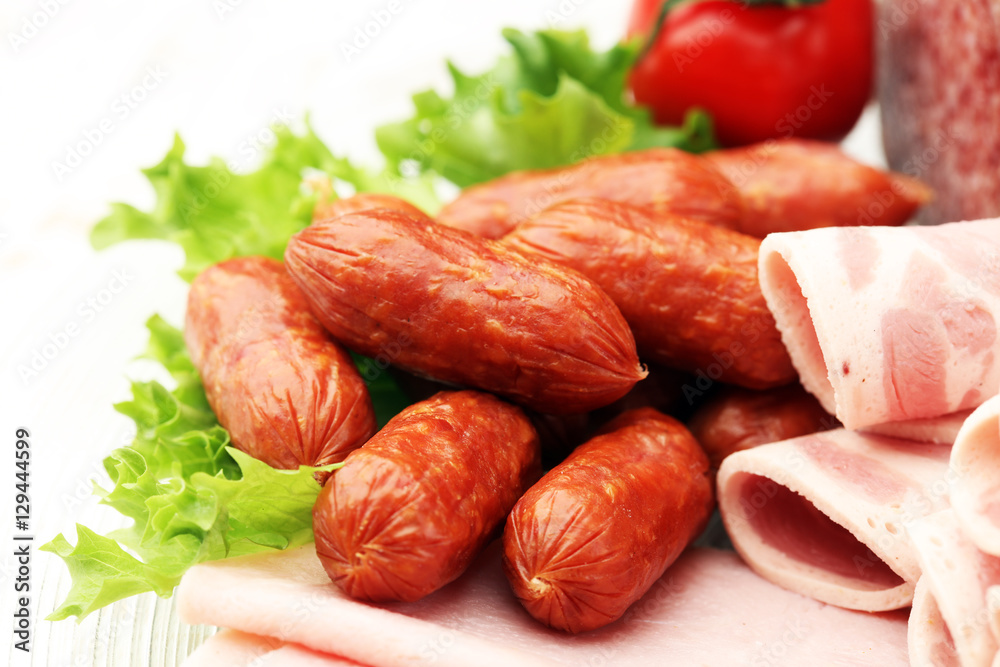Food tray with delicious salami, pieces of sliced ham, sausage, tomatoes, salad and vegetable - Meat platter with selection - Cutting sausage and cured meat on a celebratory table. Food tray with delicious salami, pieces of sliced ham, sausage, tomatoes, salad and vegetable - Meat platter with selection - Cutting sausage and cured meat on a celebratory table.