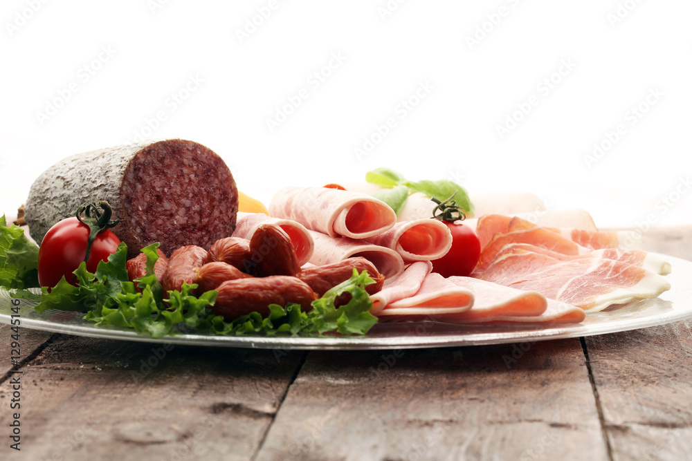 Food tray with delicious salami, pieces of sliced ham, sausage, tomatoes, salad and vegetable - Meat platter with selection Food tray with delicious salami, pieces of sliced ham, sausage, tomatoes, salad and vegetable - Meat platter with selection