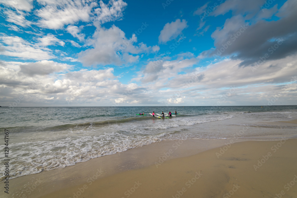 Obraz premium Group of young surfers on the beach with blue sky and white cloud summer morning offer shade to picnickers in this iconic coastal city in south Western Australia.