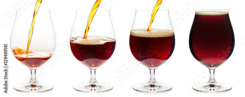 Quadro em tela Pouring dark ale beer into a tulip glass isolated