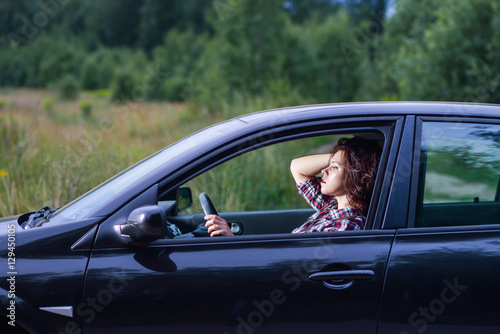 Side portrait of young woman driving a car