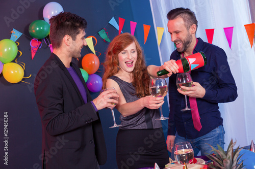 Woman pouring glass of chamapgne photo