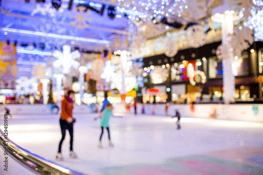 Blurred abstract defocus background of people indoor ice skating in modern shopping mall, at Christmas holiday.