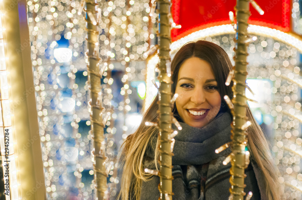 Young happy woman walking at night with christmas decorations. 