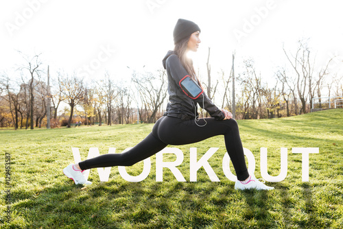 Female runner stretching in autumn park